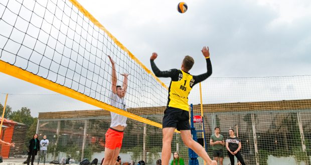 man wearing yellow and black long-sleeved shirt playing volleyball